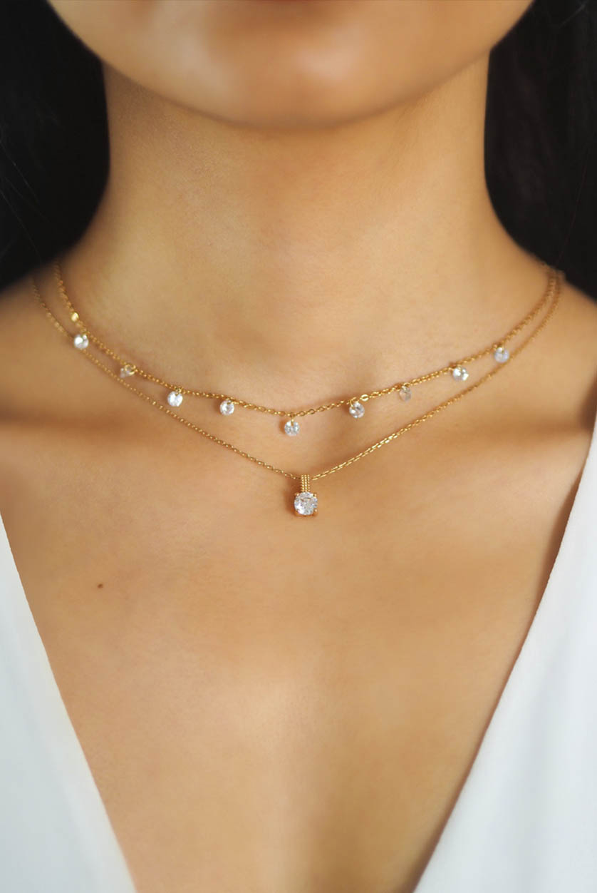 two small diamond stoned necklaces on person neck